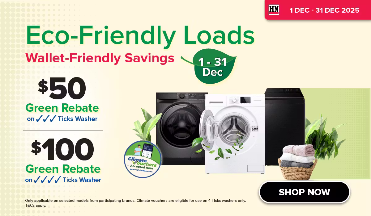 Woman wearing an olive green blazer and light blue jeans walking in an urban setting.