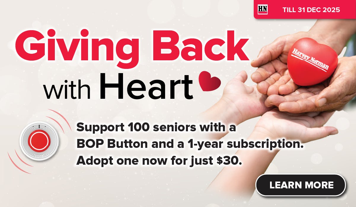 Man in a gray blazer over a dark gray shirt standing on stairs in an urban background.