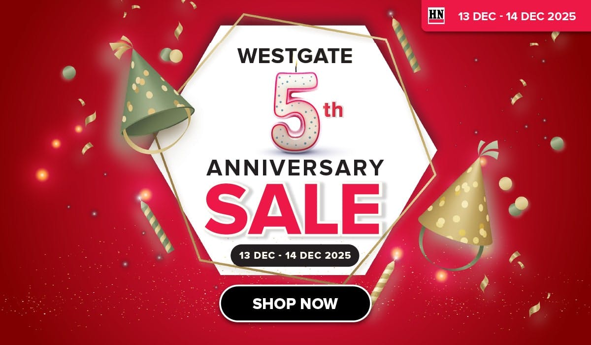 Woman wearing an olive green blazer and light blue jeans walking in an urban setting.