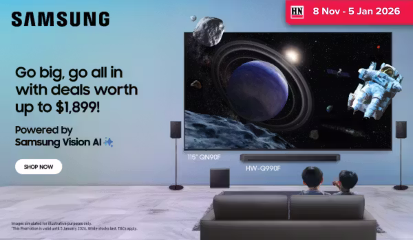 Man in a gray blazer over a dark gray shirt standing on stairs in an urban background.