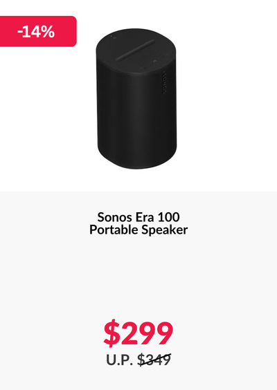 Woman wearing an olive green blazer and light blue jeans walking in an urban setting.