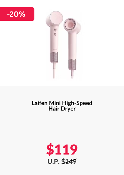 Woman wearing an olive green blazer and light blue jeans walking in an urban setting.