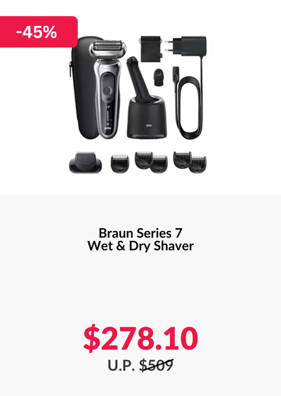 Man in a gray blazer over a dark gray shirt standing on stairs in an urban background.