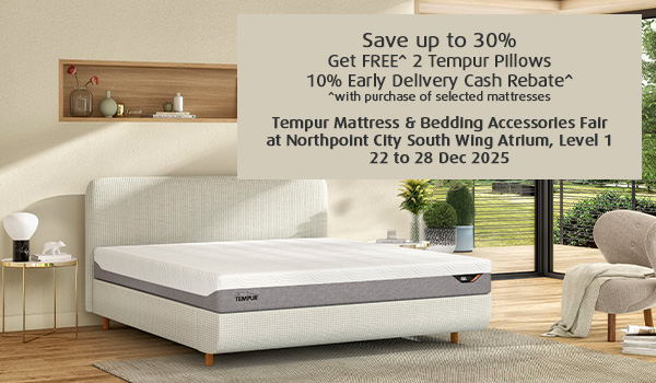 Man in a gray blazer over a dark gray shirt standing on stairs in an urban background.