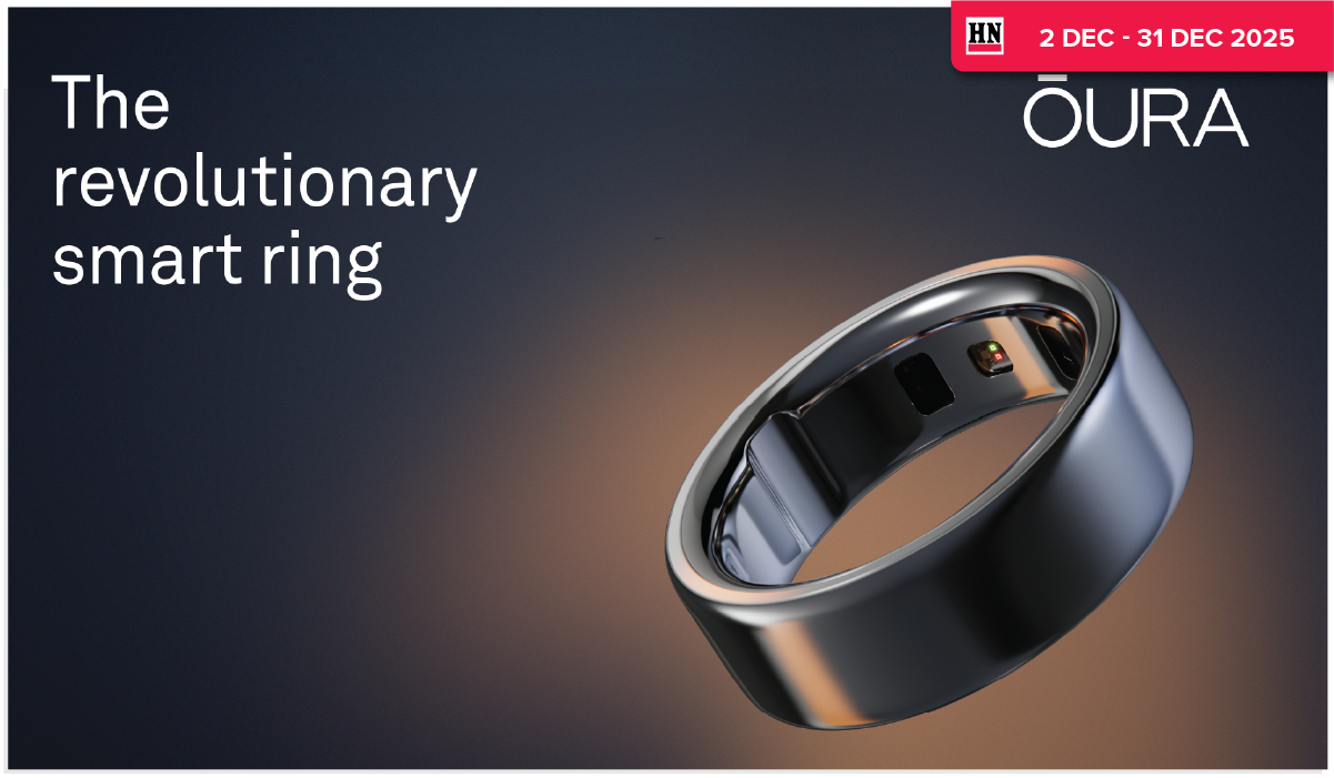 Woman wearing an olive green blazer and light blue jeans walking in an urban setting.