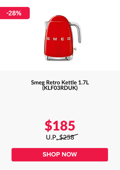 Man in a gray blazer over a dark gray shirt standing on stairs in an urban background.