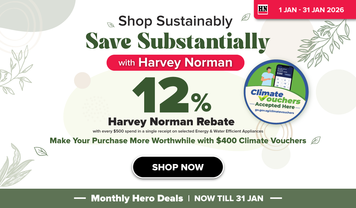 Man in a gray blazer over a dark gray shirt standing on stairs in an urban background.