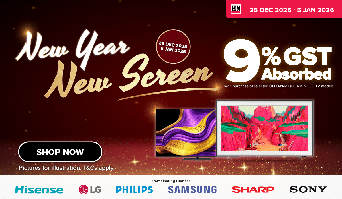 Man in a gray blazer over a dark gray shirt standing on stairs in an urban background.