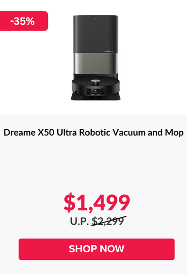 Man in a gray blazer over a dark gray shirt standing on stairs in an urban background.