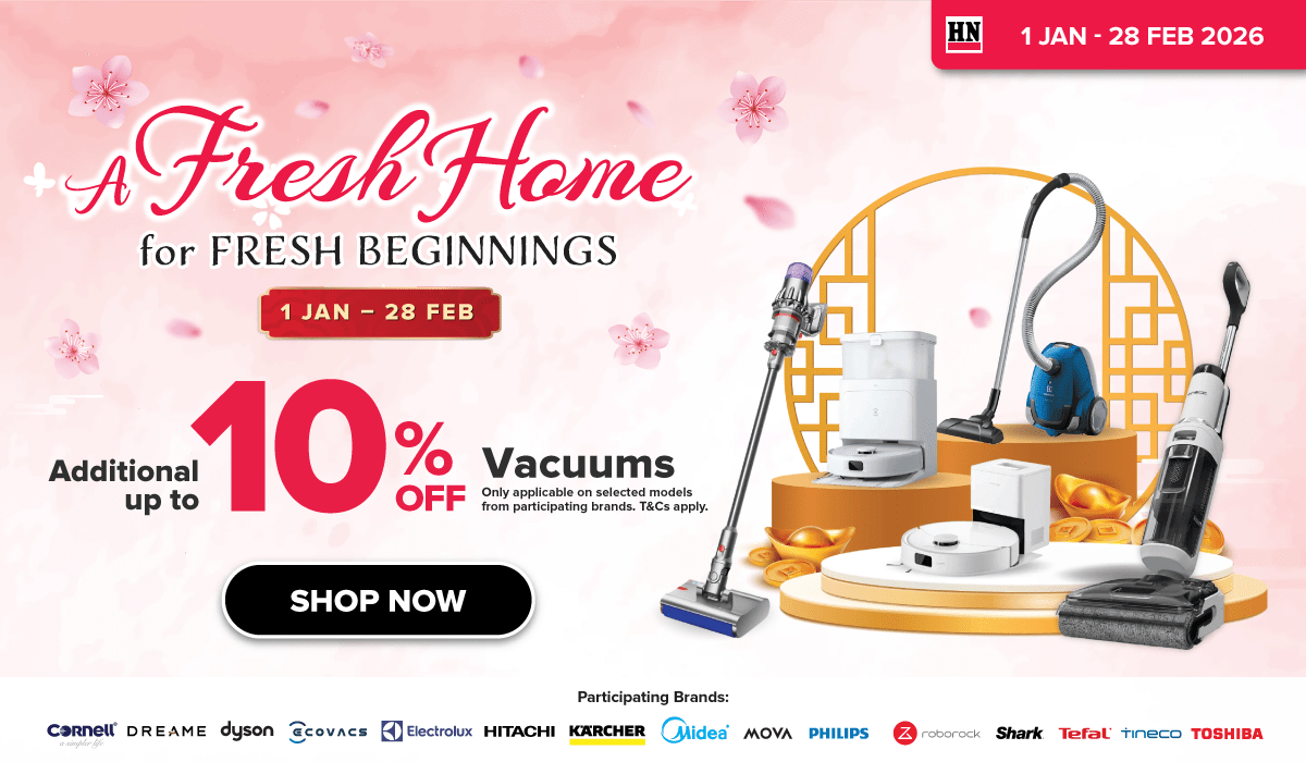 Woman wearing an olive green blazer and light blue jeans walking in an urban setting.