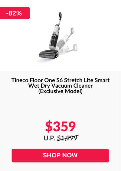 Man in a gray blazer over a dark gray shirt standing on stairs in an urban background.