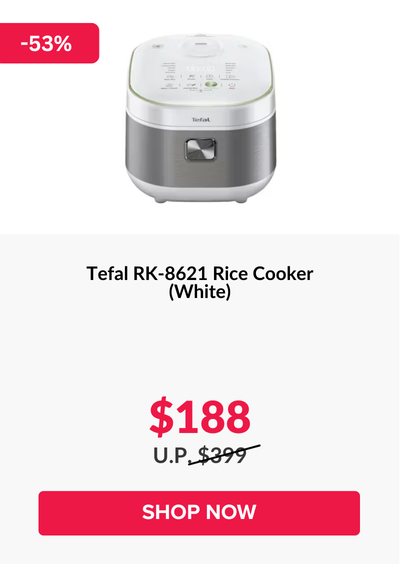 Man in a gray blazer over a dark gray shirt standing on stairs in an urban background.