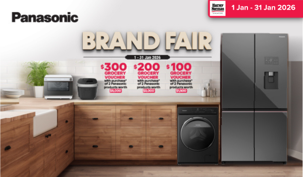 Man in a gray blazer over a dark gray shirt standing on stairs in an urban background.