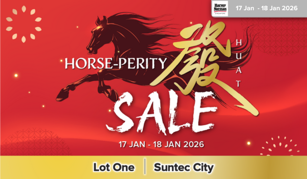 Woman wearing an olive green blazer and light blue jeans walking in an urban setting.