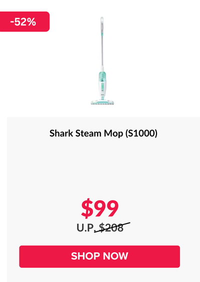 Woman wearing an olive green blazer and light blue jeans walking in an urban setting.