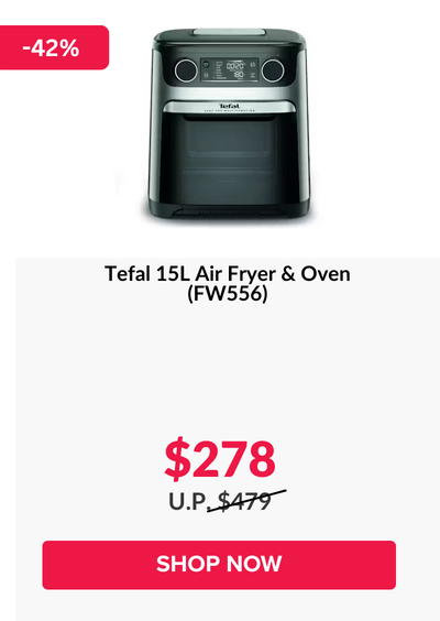 Woman wearing an olive green blazer and light blue jeans walking in an urban setting.