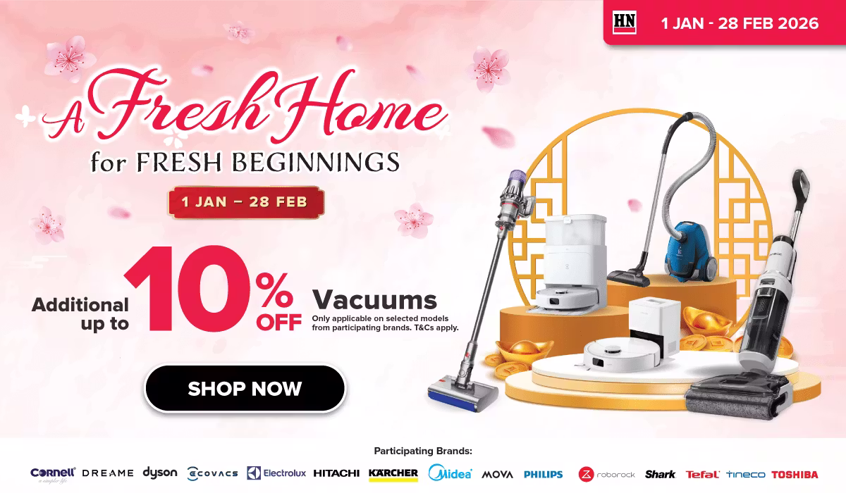 Woman wearing an olive green blazer and light blue jeans walking in an urban setting.