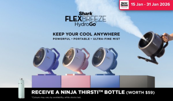 Woman wearing an olive green blazer and light blue jeans walking in an urban setting.