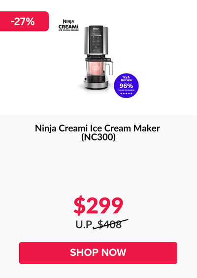 Man in a gray blazer over a dark gray shirt standing on stairs in an urban background.