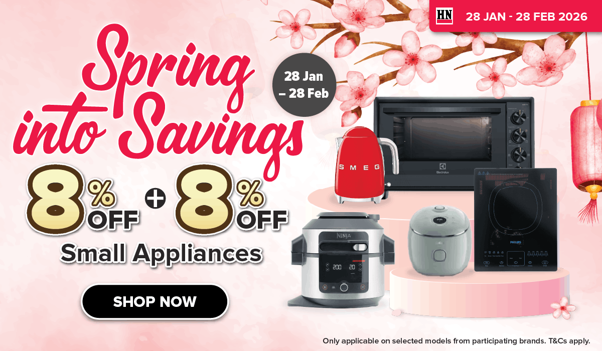 Woman wearing an olive green blazer and light blue jeans walking in an urban setting.