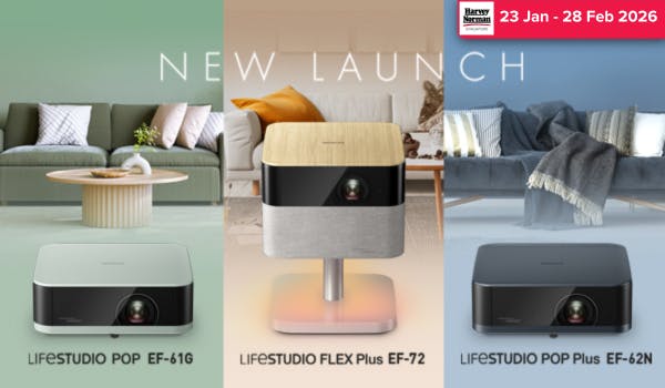 Man in a gray blazer over a dark gray shirt standing on stairs in an urban background.