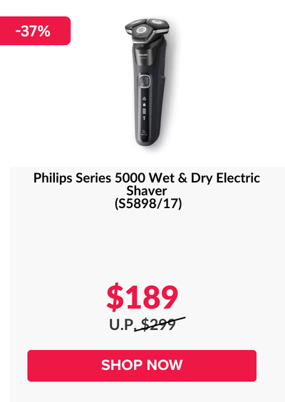 Woman wearing an olive green blazer and light blue jeans walking in an urban setting.