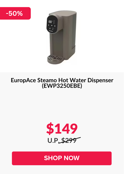 Man in a gray blazer over a dark gray shirt standing on stairs in an urban background.