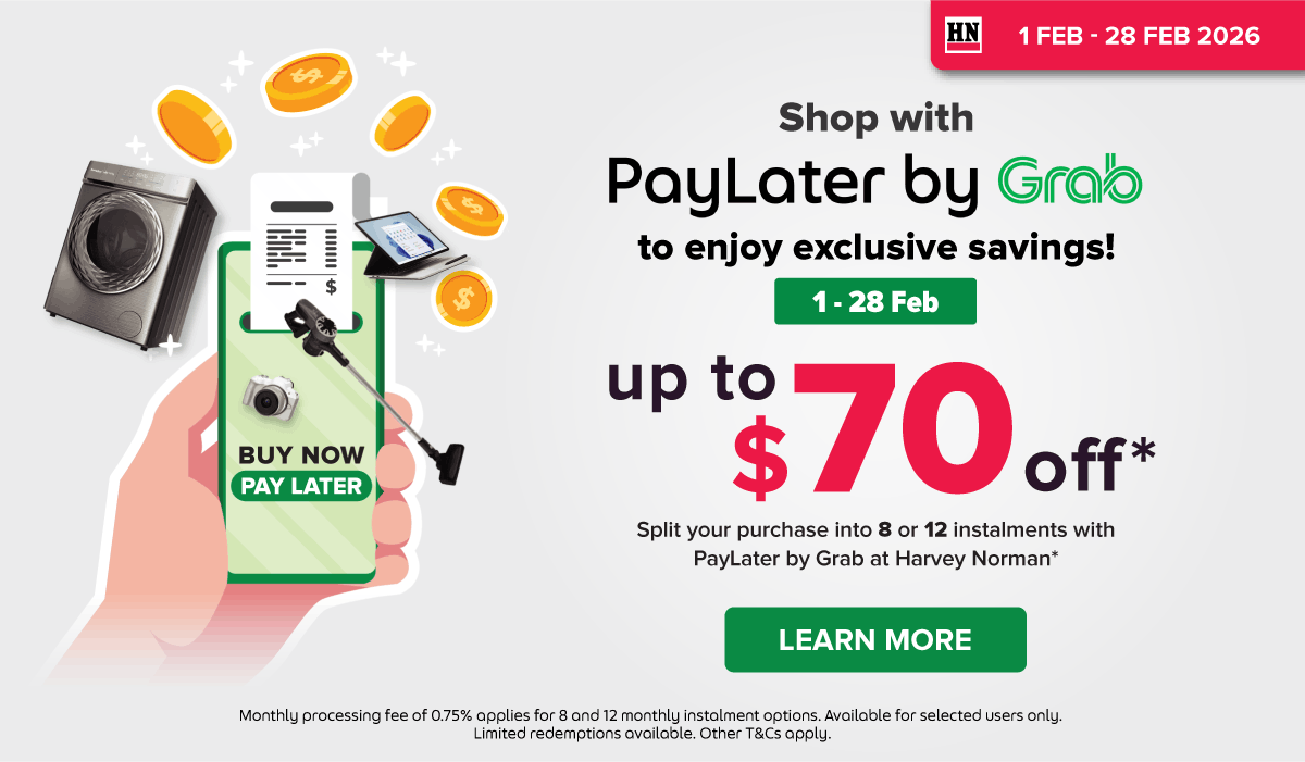 Woman wearing an olive green blazer and light blue jeans walking in an urban setting.