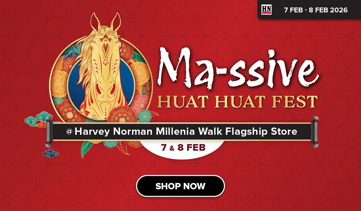 Woman wearing an olive green blazer and light blue jeans walking in an urban setting.