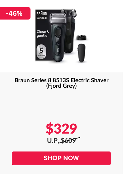 Man in a gray blazer over a dark gray shirt standing on stairs in an urban background.