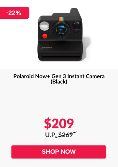 Man in a gray blazer over a dark gray shirt standing on stairs in an urban background.