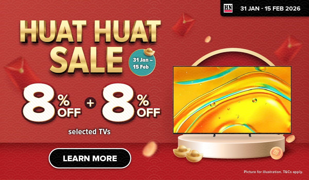 Woman wearing an olive green blazer and light blue jeans walking in an urban setting.