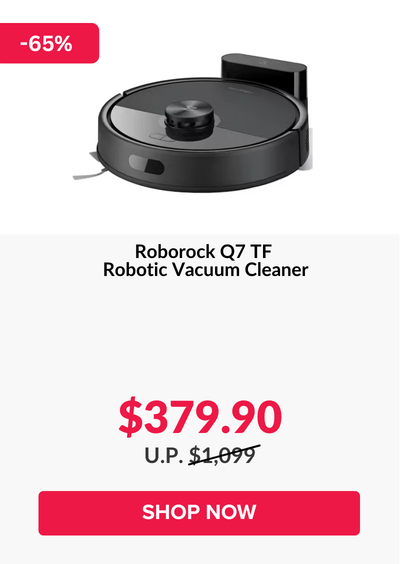 Man in a gray blazer over a dark gray shirt standing on stairs in an urban background.