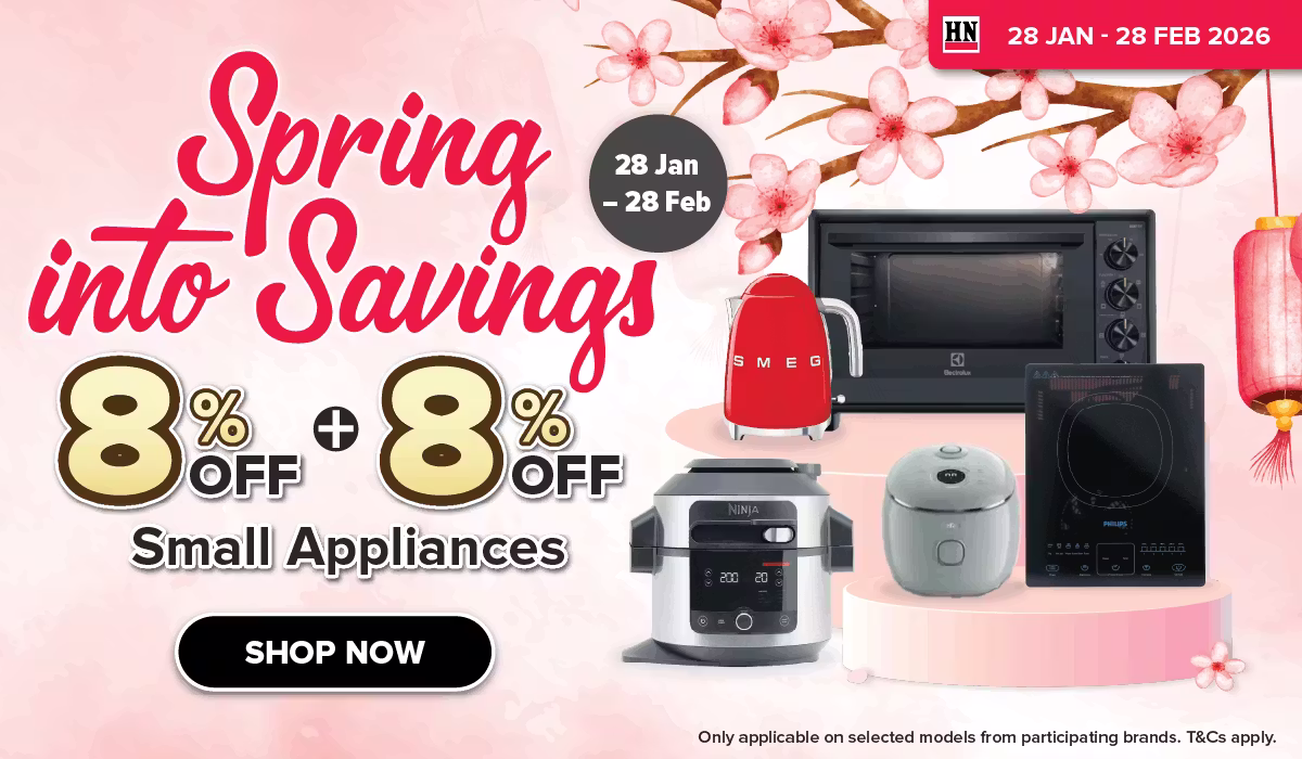 Man in a gray blazer over a dark gray shirt standing on stairs in an urban background.