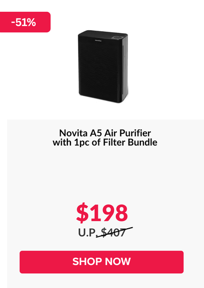 Woman wearing an olive green blazer and light blue jeans walking in an urban setting.