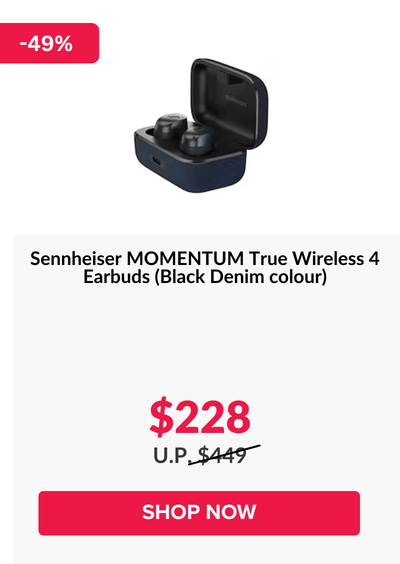 Woman wearing an olive green blazer and light blue jeans walking in an urban setting.