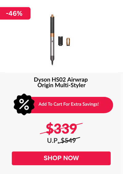 Man in a gray blazer over a dark gray shirt standing on stairs in an urban background.