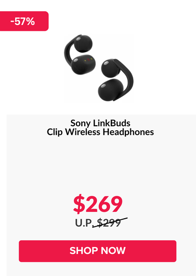 Woman wearing an olive green blazer and light blue jeans walking in an urban setting.