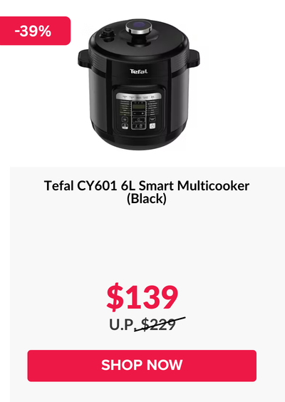 Woman wearing an olive green blazer and light blue jeans walking in an urban setting.