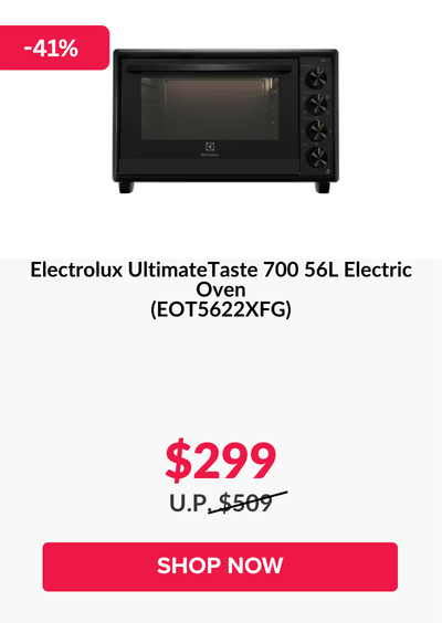 Man in a gray blazer over a dark gray shirt standing on stairs in an urban background.