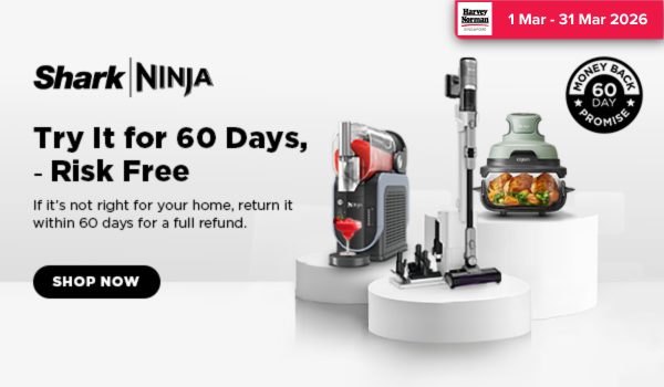 Woman wearing an olive green blazer and light blue jeans walking in an urban setting.