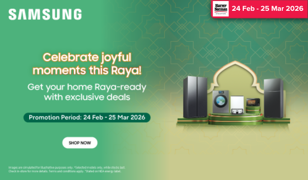 Man in a gray blazer over a dark gray shirt standing on stairs in an urban background.