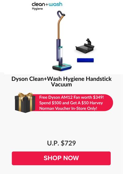 Man in a gray blazer over a dark gray shirt standing on stairs in an urban background.