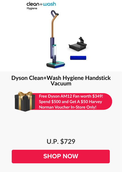 Man in a gray blazer over a dark gray shirt standing on stairs in an urban background.