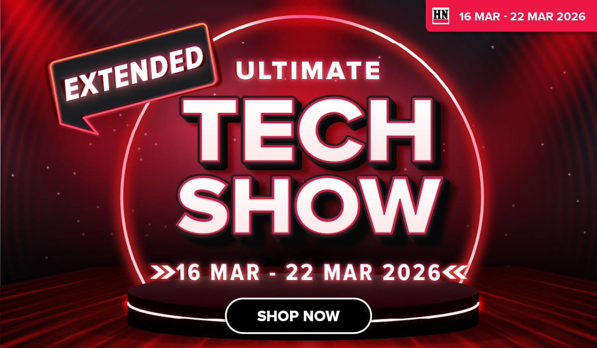 Man in a gray blazer over a dark gray shirt standing on stairs in an urban background.