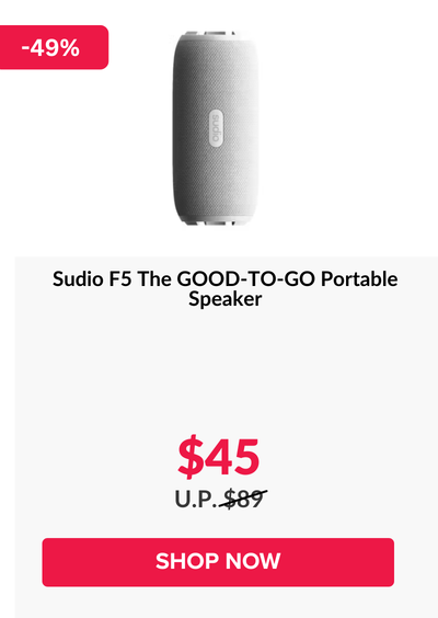 Woman wearing an olive green blazer and light blue jeans walking in an urban setting.