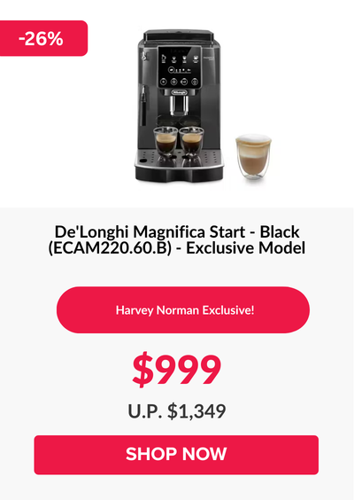 Man in a gray blazer over a dark gray shirt standing on stairs in an urban background.