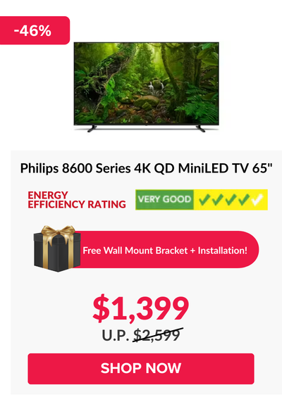 Man in a gray blazer over a dark gray shirt standing on stairs in an urban background.