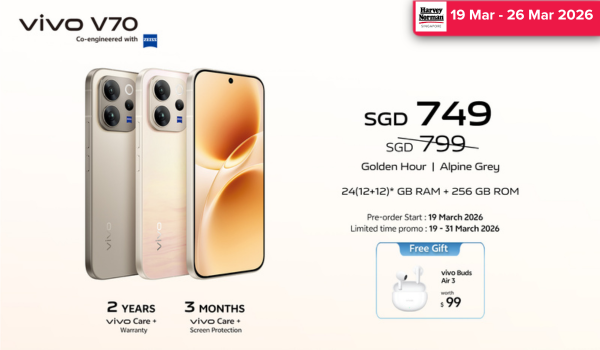 Man in a gray blazer over a dark gray shirt standing on stairs in an urban background.