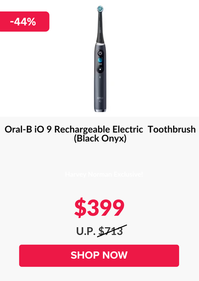 Man in a gray blazer over a dark gray shirt standing on stairs in an urban background.